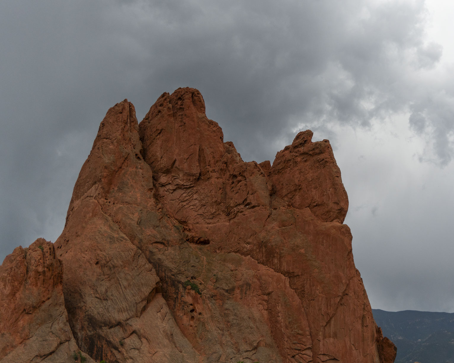 The texture of a big red rock against a cloudy sky